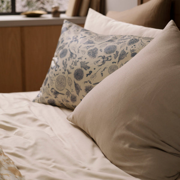 Decorative pillows on a bed with a window in the background