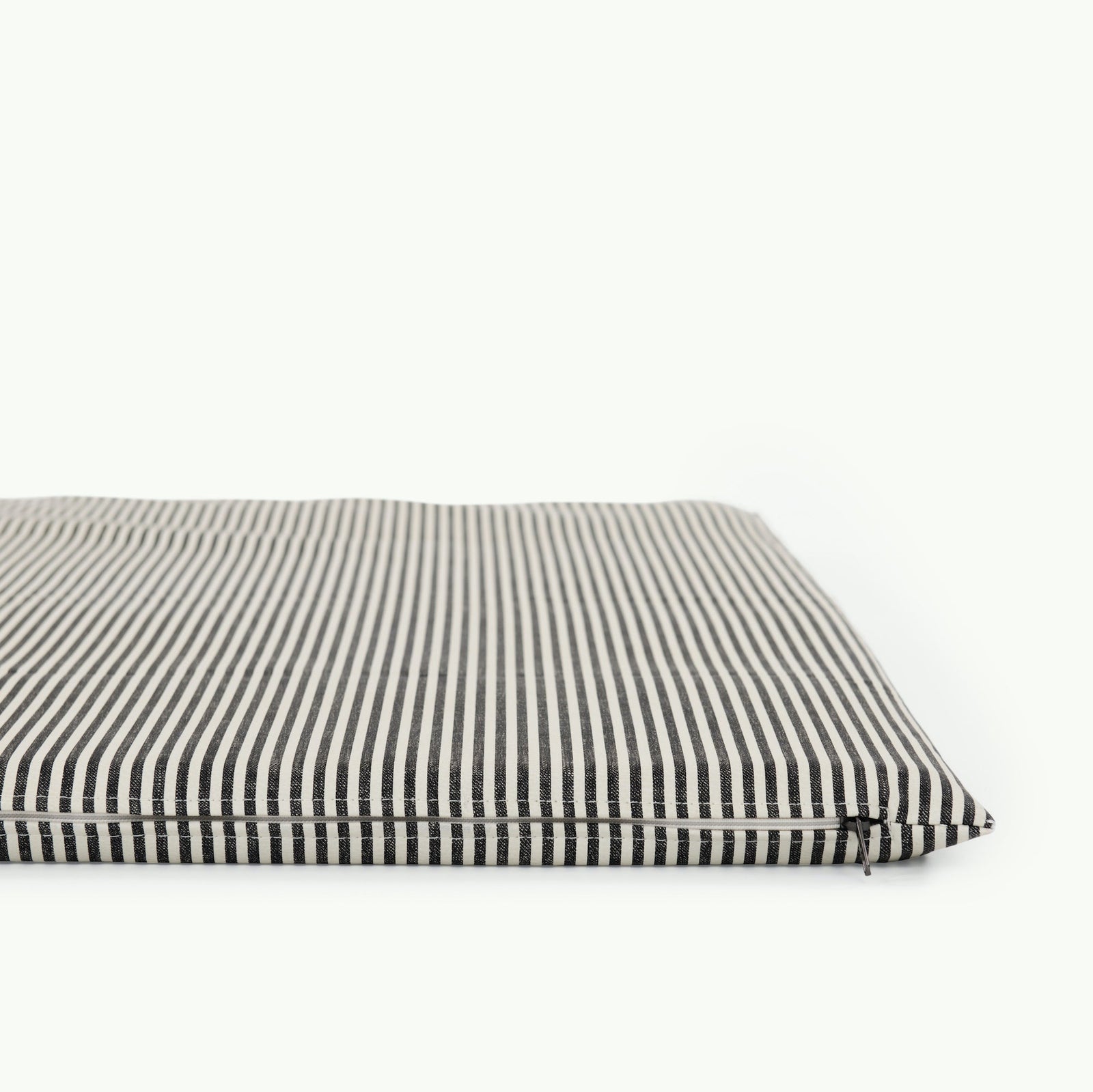 The Gathre Wholesale Padded Changing Mat is displayed against a plain white background, featuring black and white vertical stripes. The mat appears thin, flat, and has neatly sewn edges.