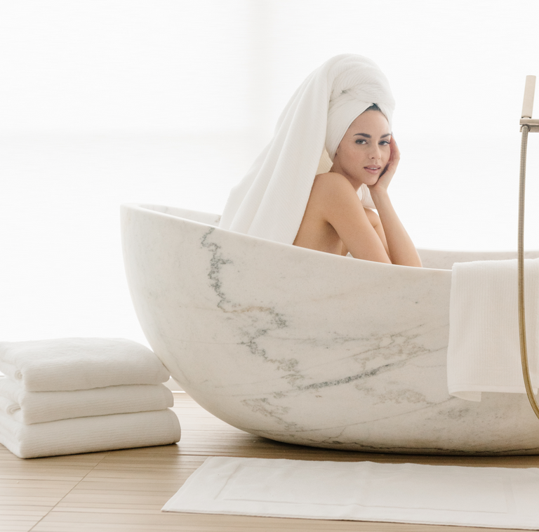 Woman in bath tub with towel on head