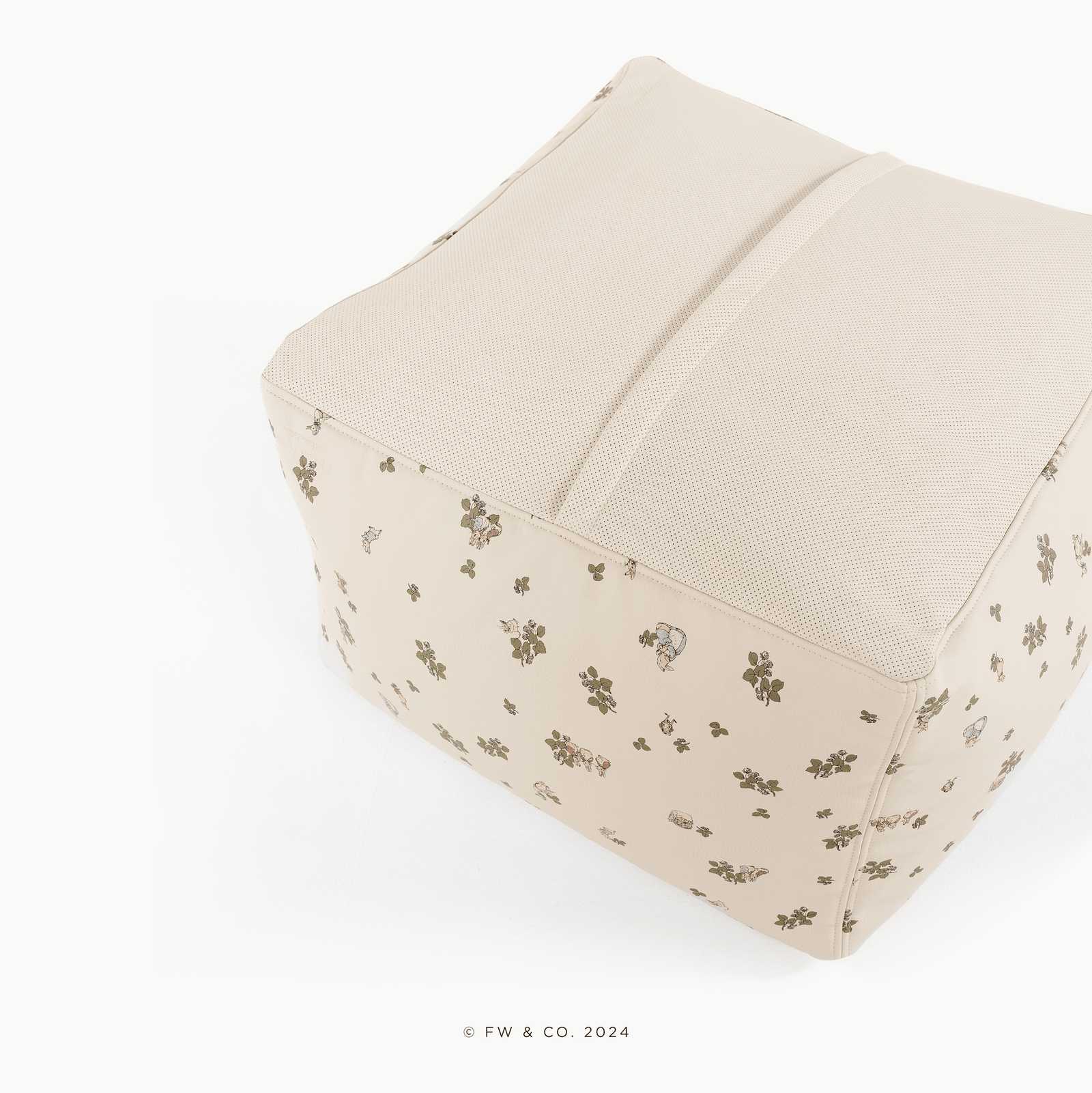 The Gathre Wholesale Pouf is a beige fabric cube ottoman with a light mesh top and a floral print of small animals and plants. It features visible seams, a soft minimalist design, and is photographed on a white background.