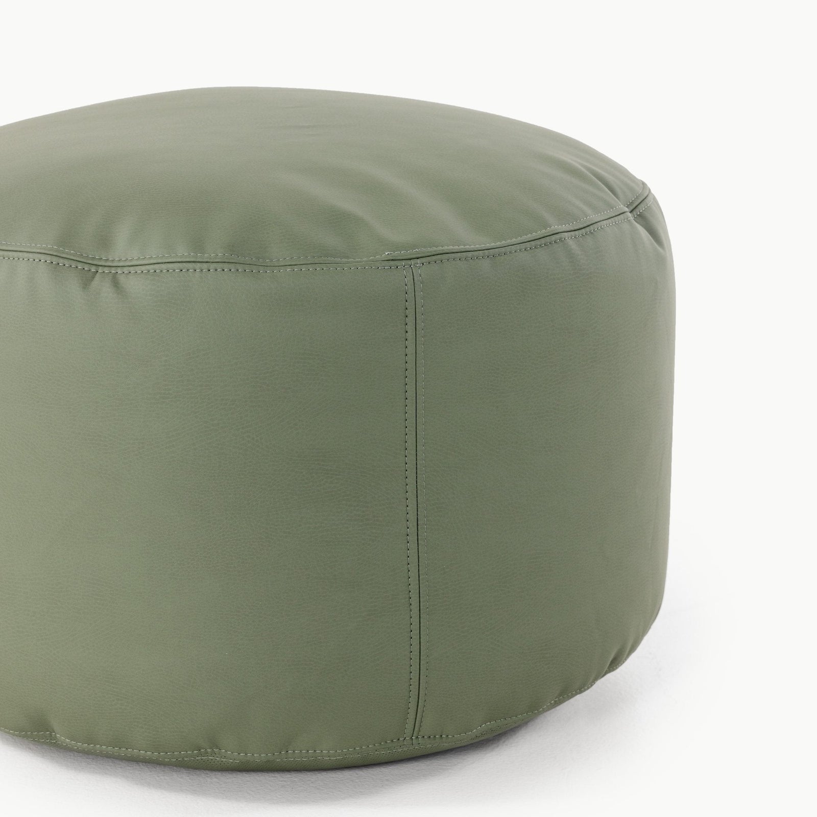 The Gathre Wholesale Pouf is a round, green ottoman featuring smooth, stitched upholstery. Shown here on a white surface against a plain white background.