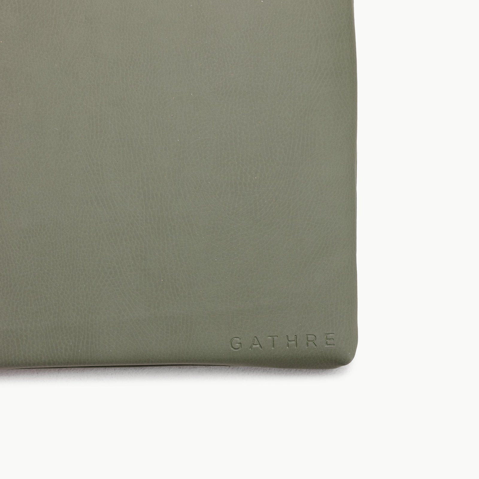 A close-up of the Wholesale Padded Changing Mat by Gathre in sage green leather, featuring the brand's name subtly embossed near the bottom right corner.