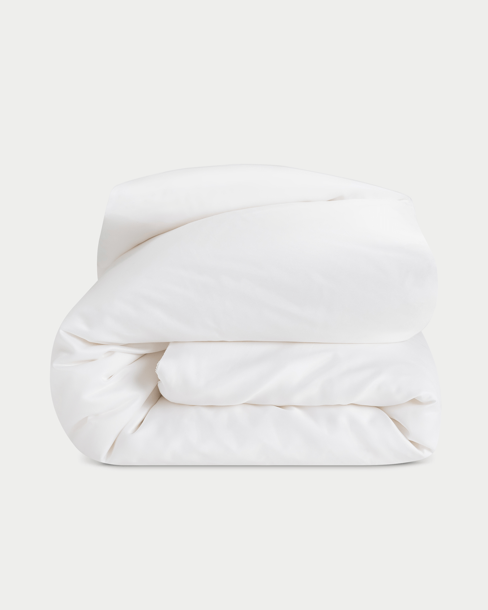 Silk comforter folded up with a white background 