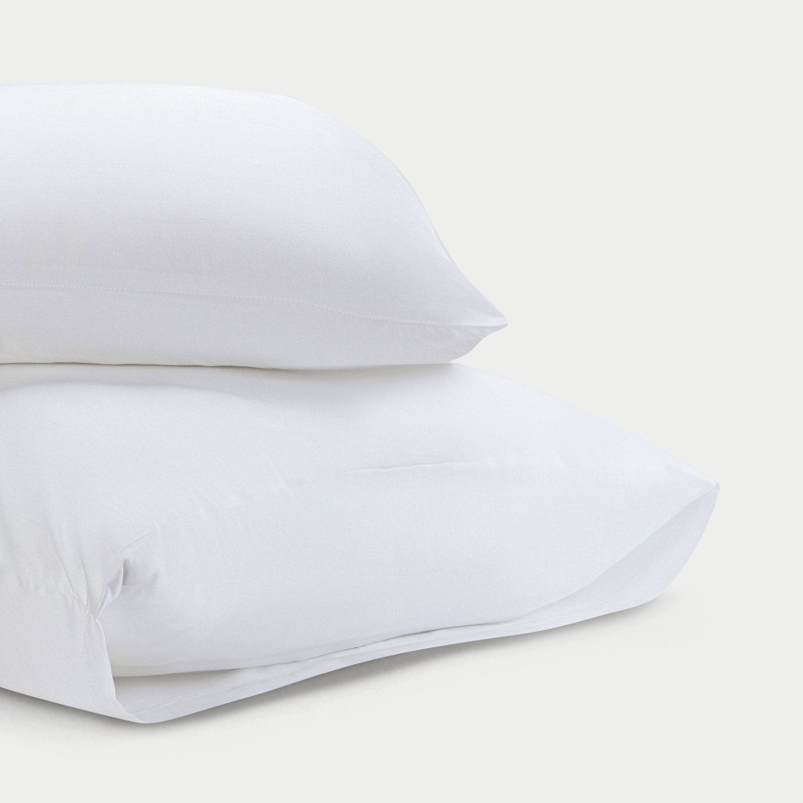 Two standard/king white pillowcases with plain background