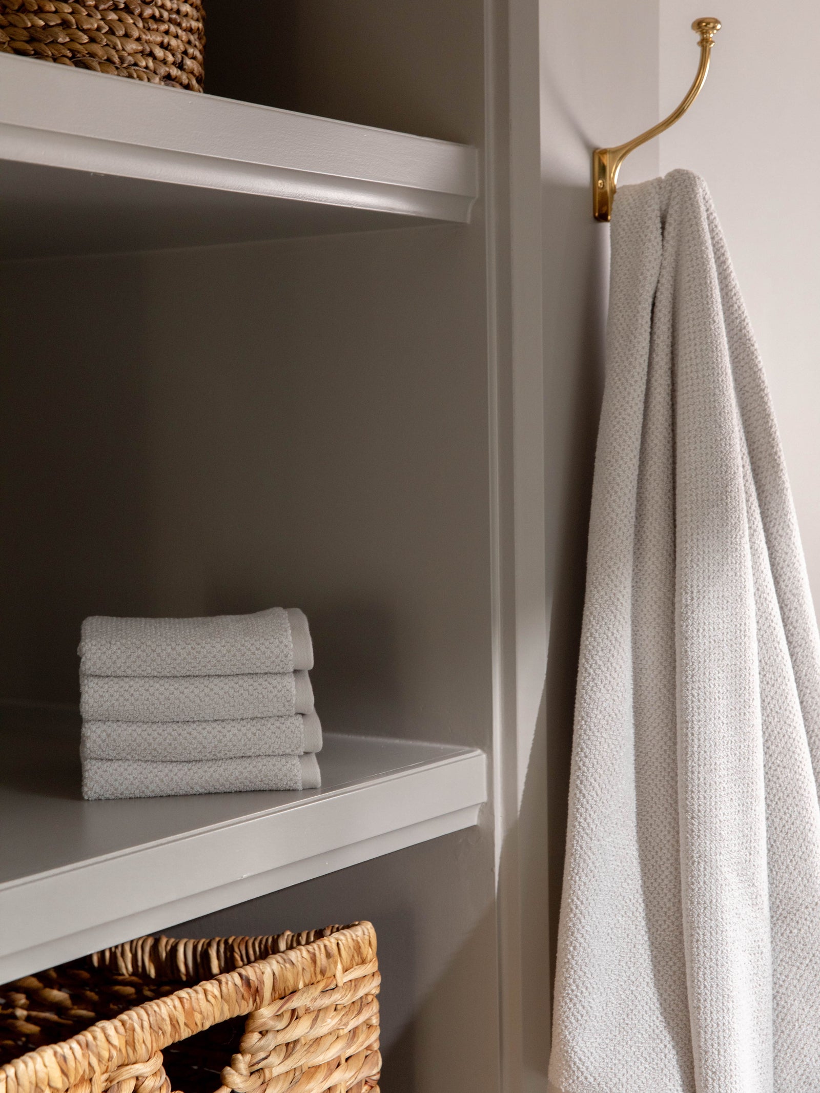 Complete Nantucket Bath Bundle in the color Heathered Light Grey. Photo of Complete Nantucket Bath Bundle taken as the hand towels, wash clothes, and bath towels are neatly placed on shelves in a bathroom. 