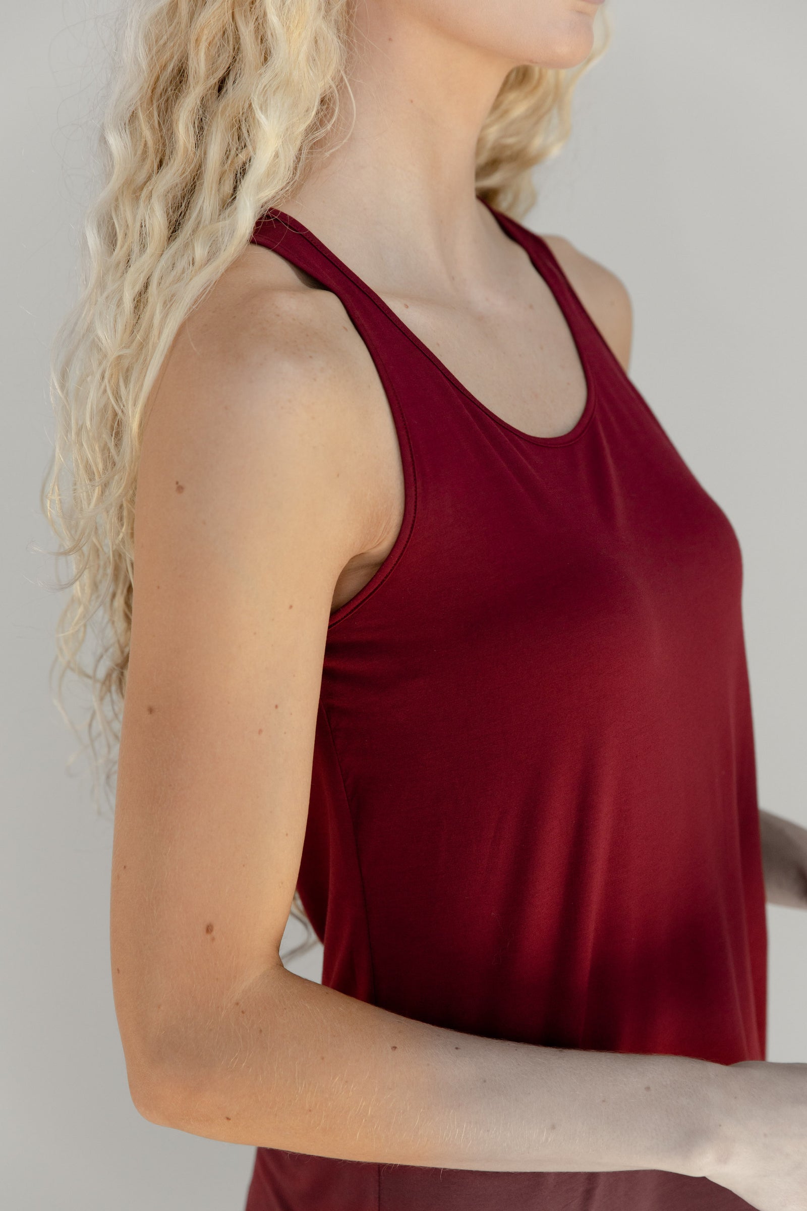 A closeup of a woman wearing a red Cozy Earth Stretch Knit Tank