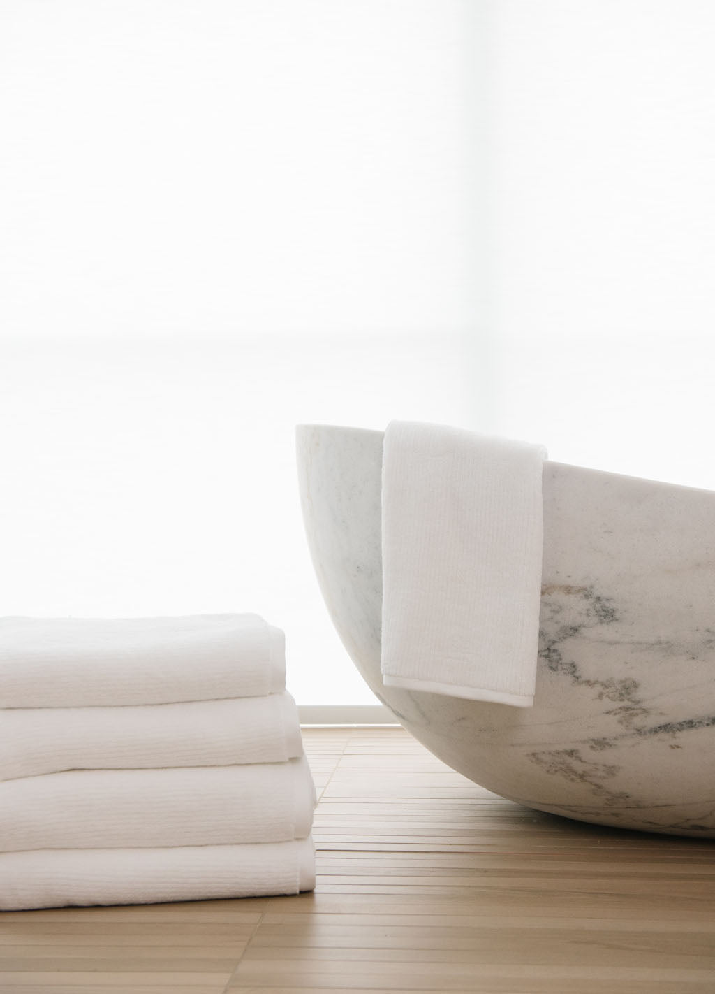 White Ribbed Terry Hand Towels in the color white next to a white marble bath tub.