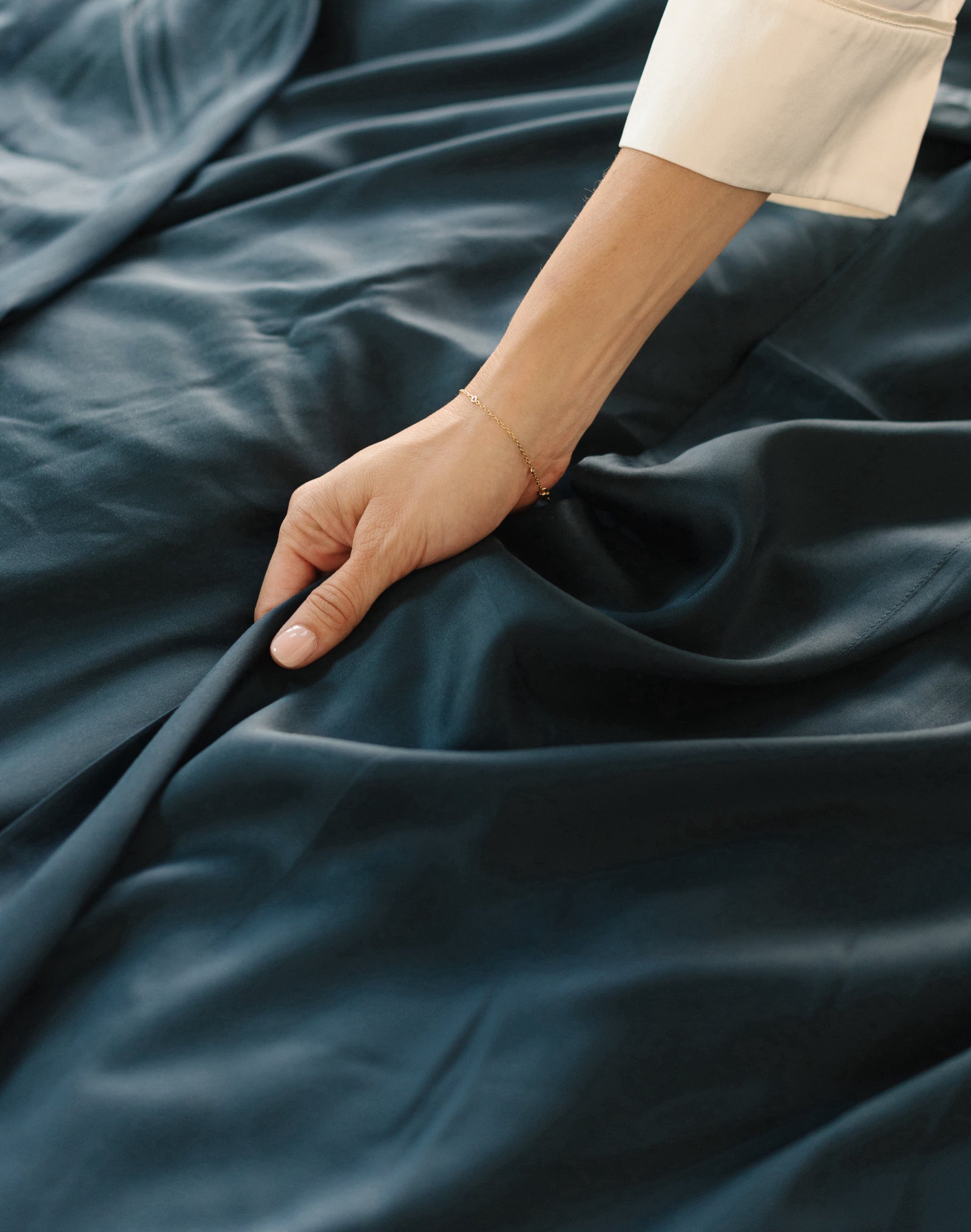 Close up of hand touching navy sheets 