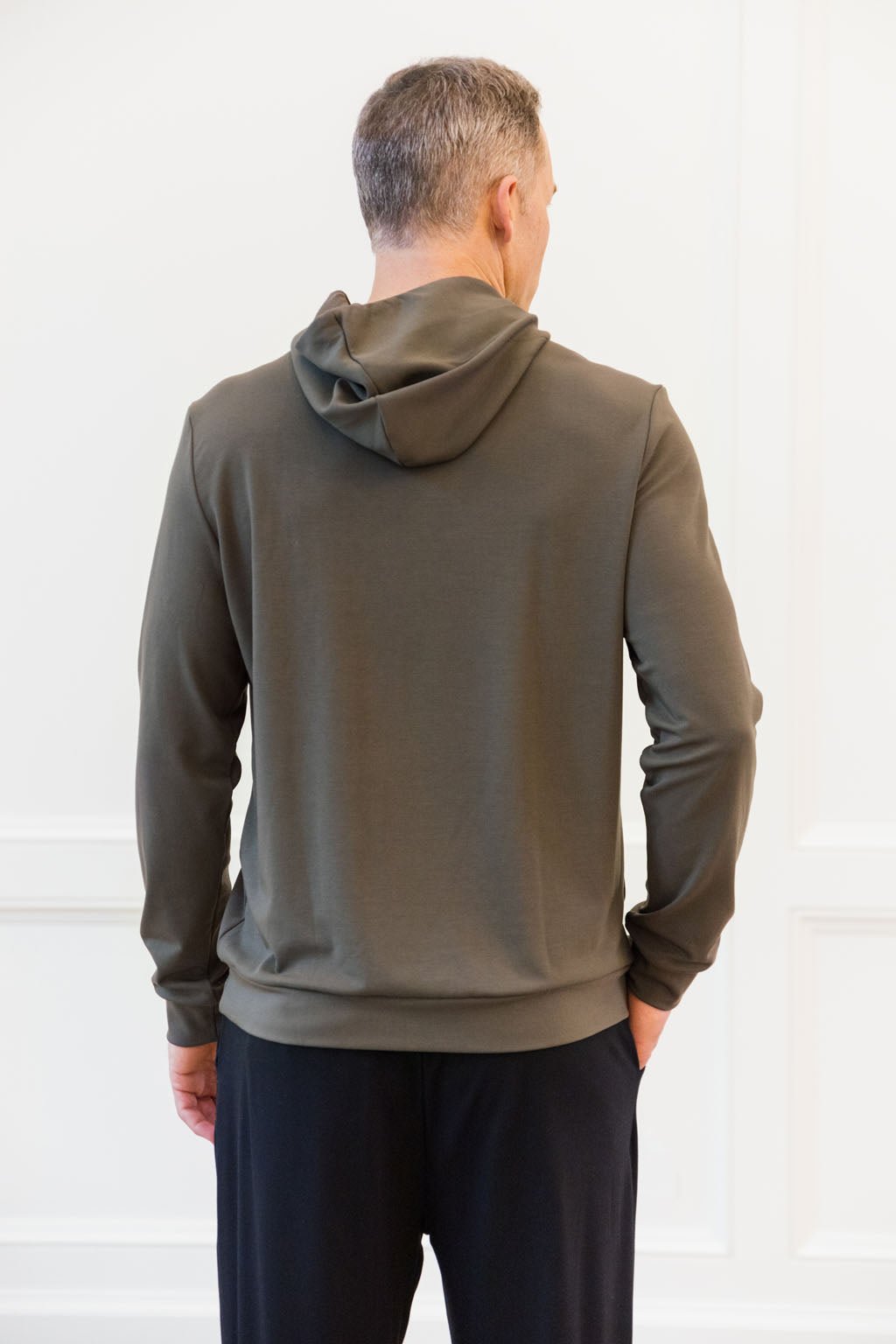 Hunter Bamboo Hoodie worn by man standing in front of white background with his back facing the camera.