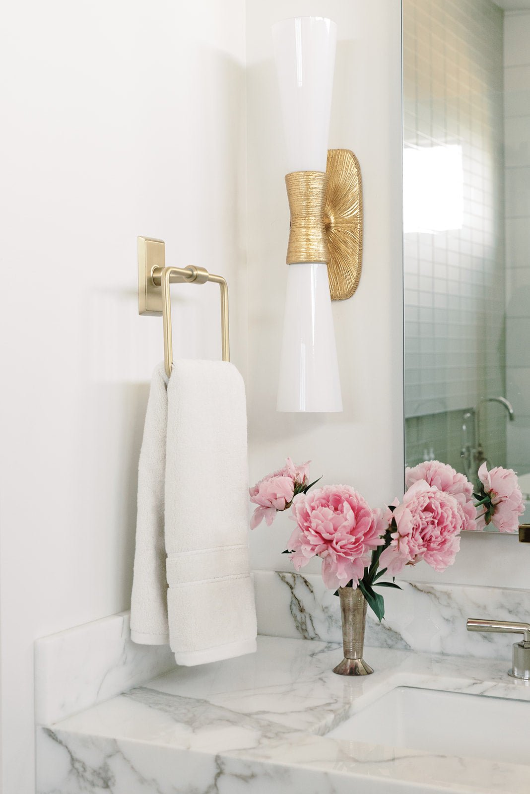 Premium Plush Hand Towel in the color Seashell. Photo of Seashell Premium Plush Hand Towel taken in a bathroom. One Premium Plush Hand Towel is hanging from a towel ring.