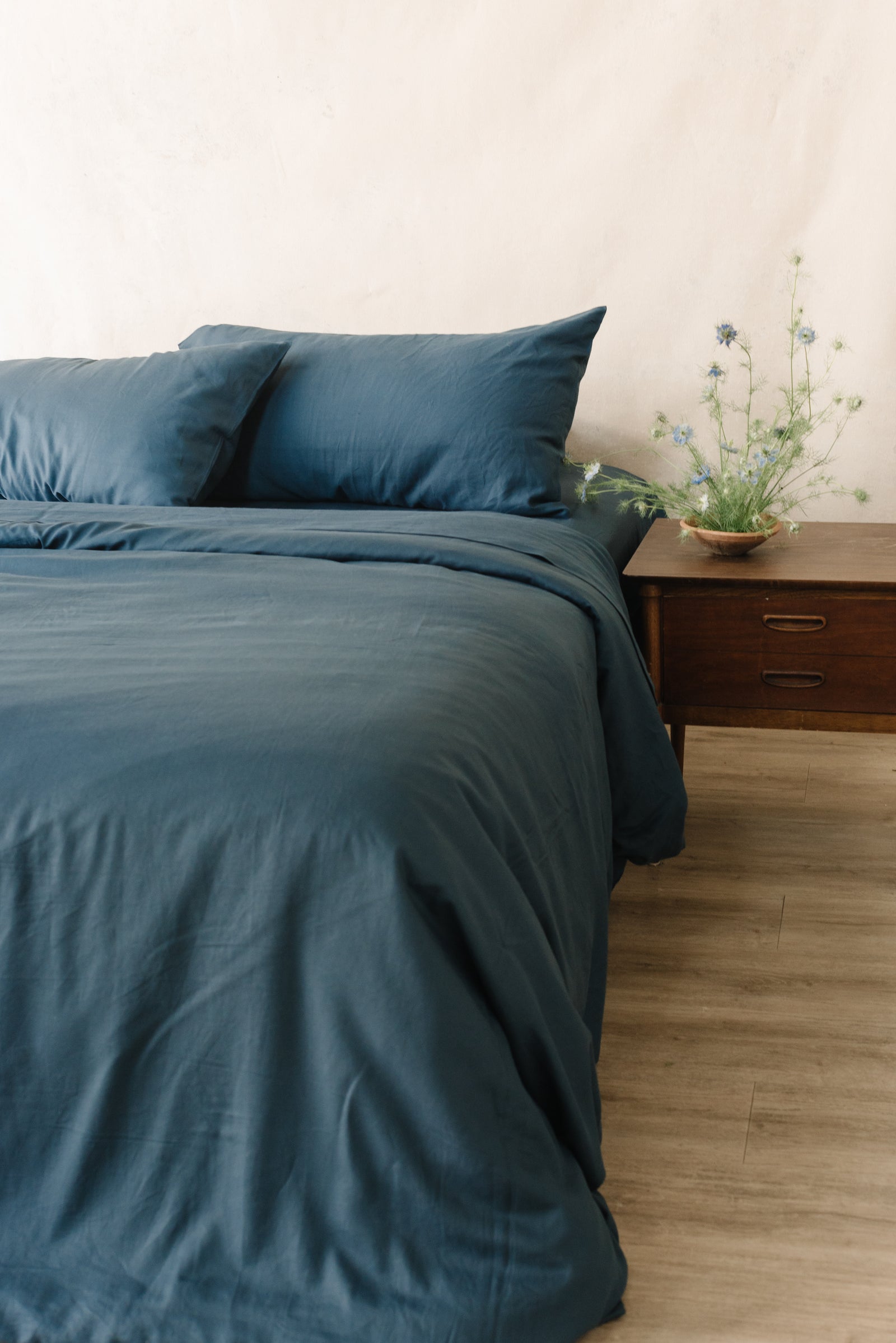 Navy Duvet Cover and comforter resting on a bed.