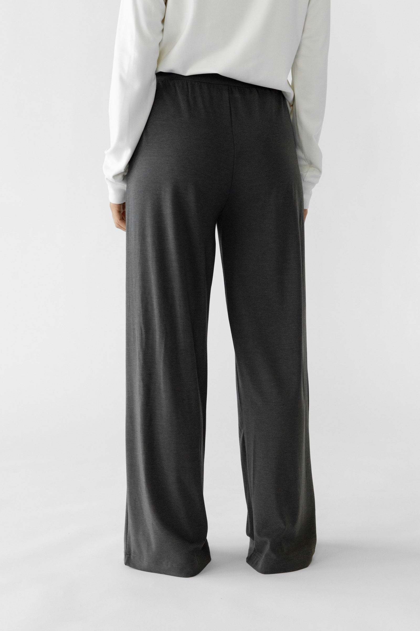 Charcoal Bamboo Wide Leg Patch Pocket Pant modeled by a woman. The photo was taken in a high contrast setting, showing off the colors and lines of the pajamas.