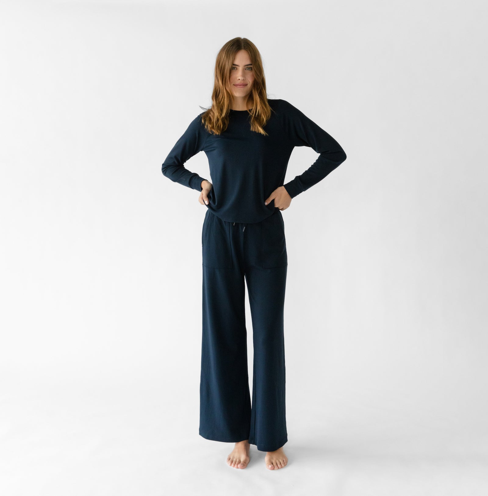 Navy Bamboo Wide Leg Patch Pocket Pant modeled by a woman. The photo was taken in a high contrast setting, showing off the colors and lines of the pajamas.