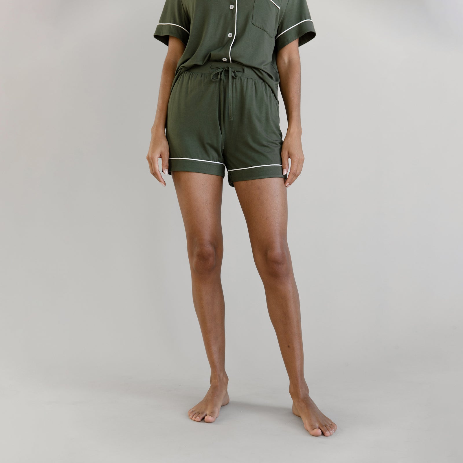 Olive Short Sleeve Pajama Set modeled by a women. The photo was taken in a light setting; showing off the pajamas.