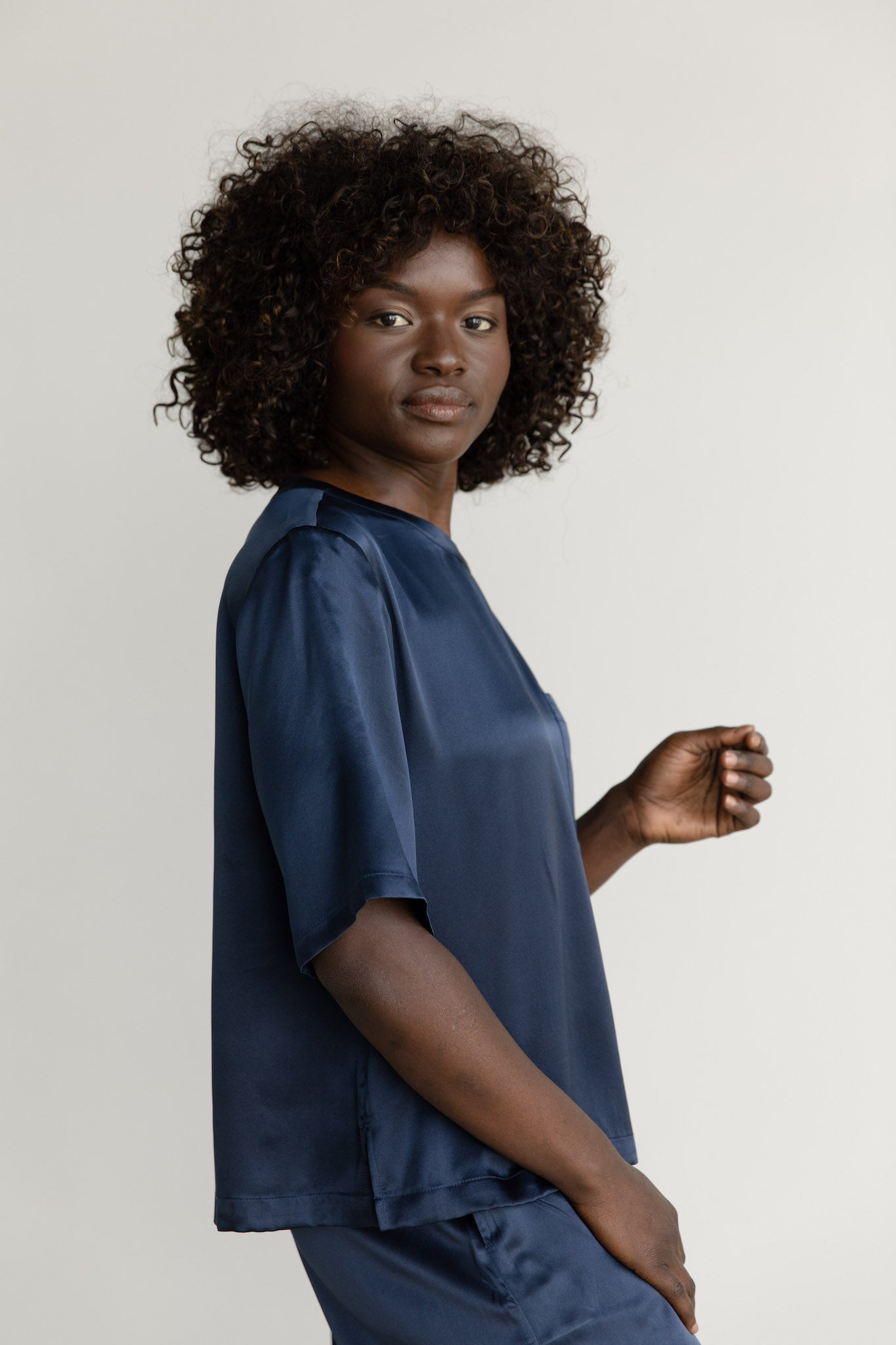 Navy Serenity Silk Scoop Neck Tee modeled by a woman. The photo was taken in a high contrast setting, showing off the colors and lines of the tee.