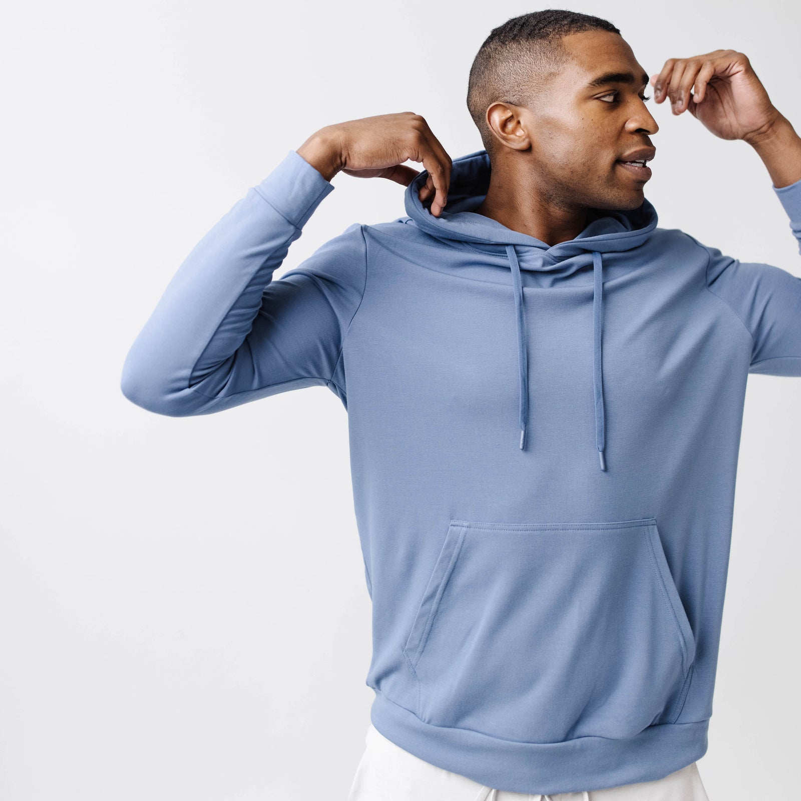 Blue Bamboo Hoodie worn by a man standing in front of white background.