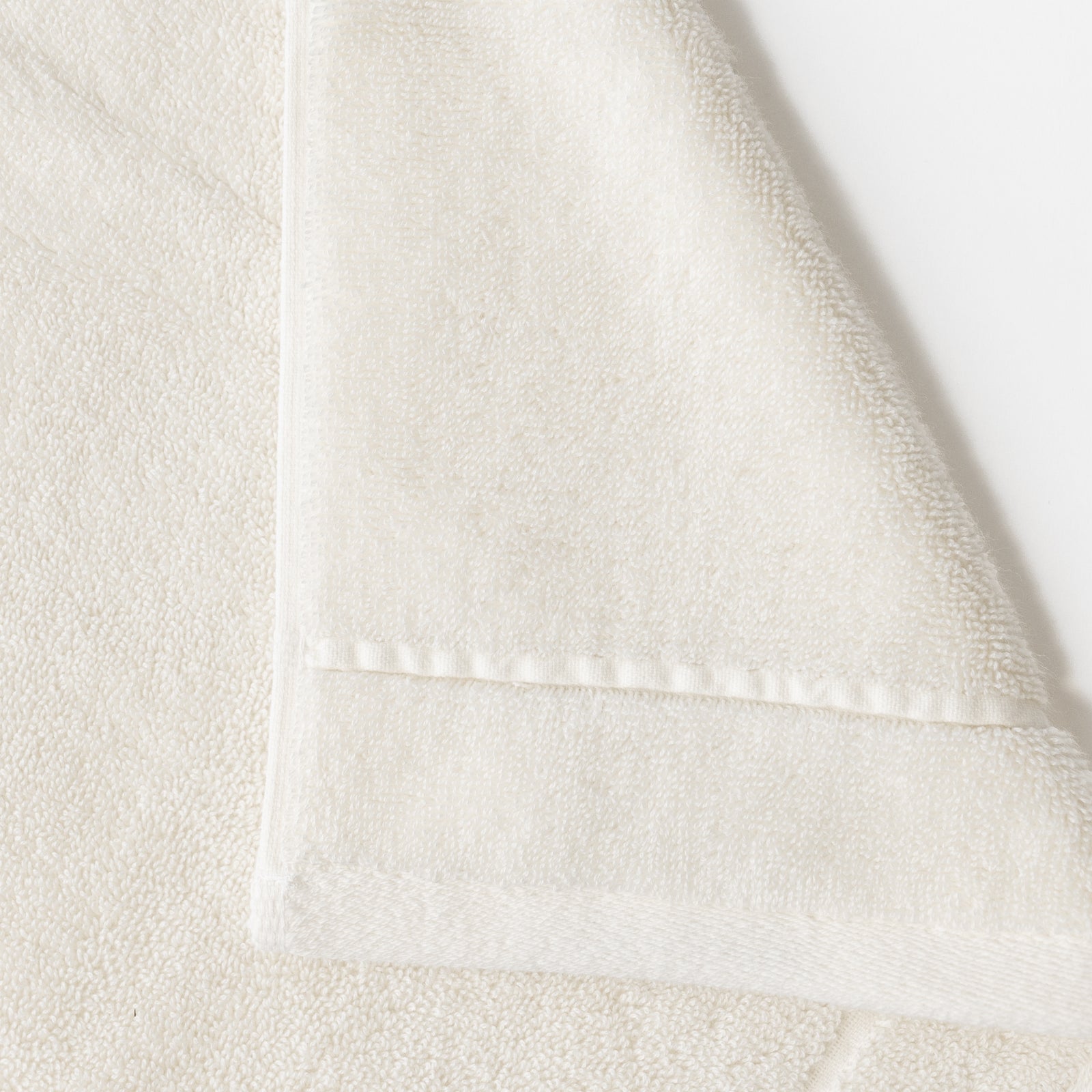 Creme Premium Plush Bath Towel. Photo of Premium Plush Bath Towels taken on a white background showing only the corner of the towel. 