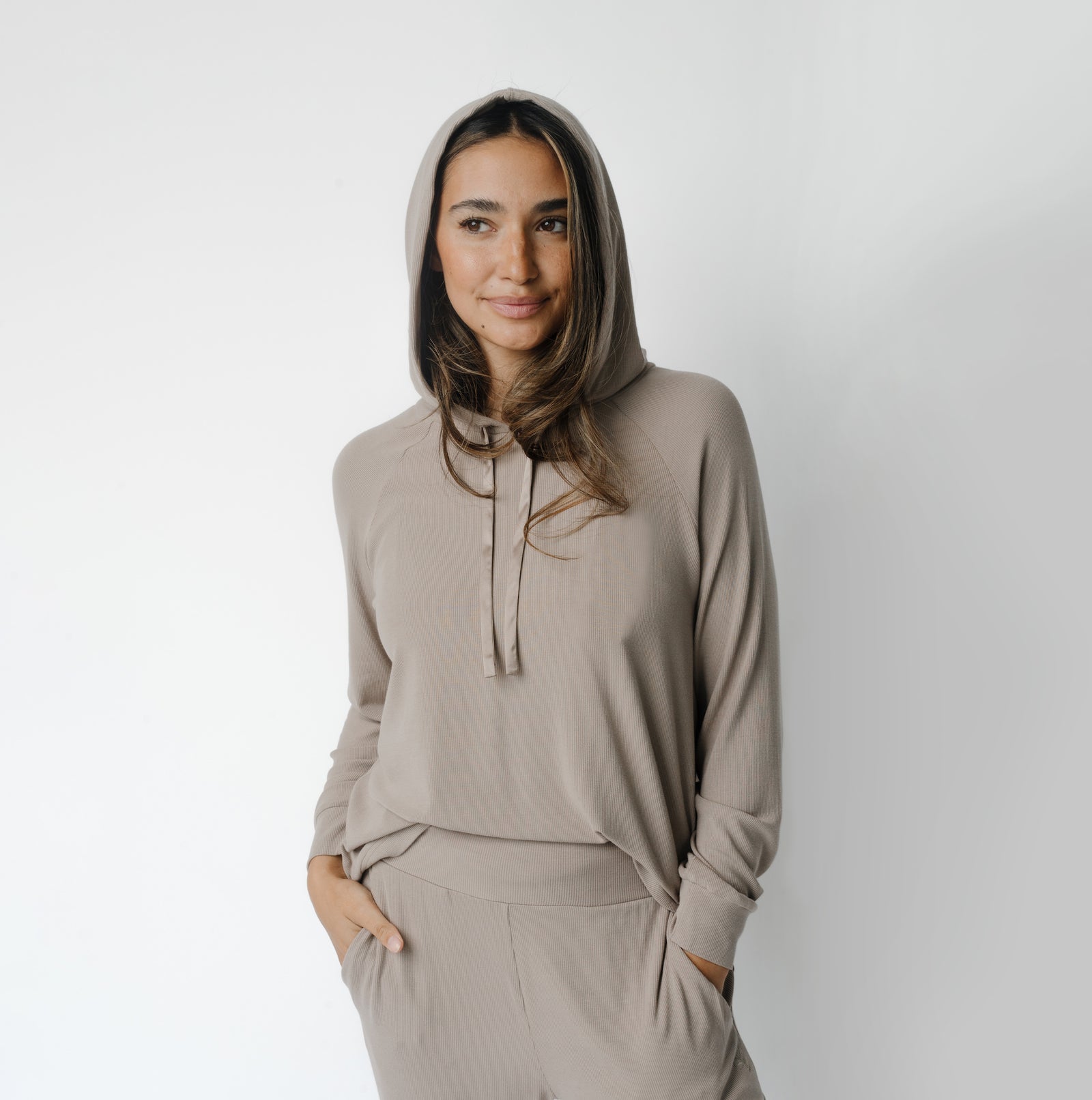 Woman wearing a Cozy Earth Rib Knit Hoodie in tan against a white background