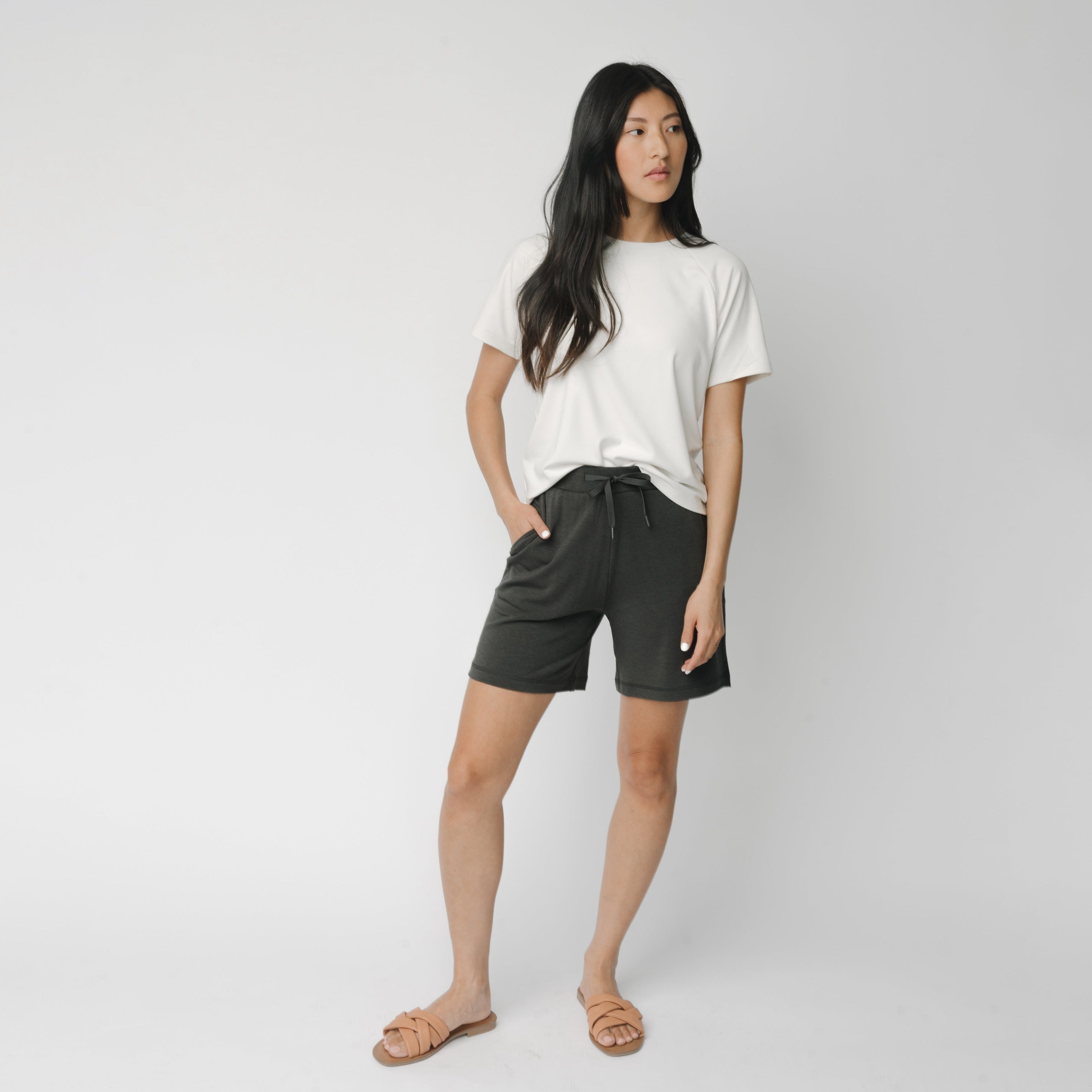 Woman wearing a white t-shirt and grey Cozy Earth Brushed Bamboo Mid-Length Shorts shorts on a plain background |Color:Charcoal