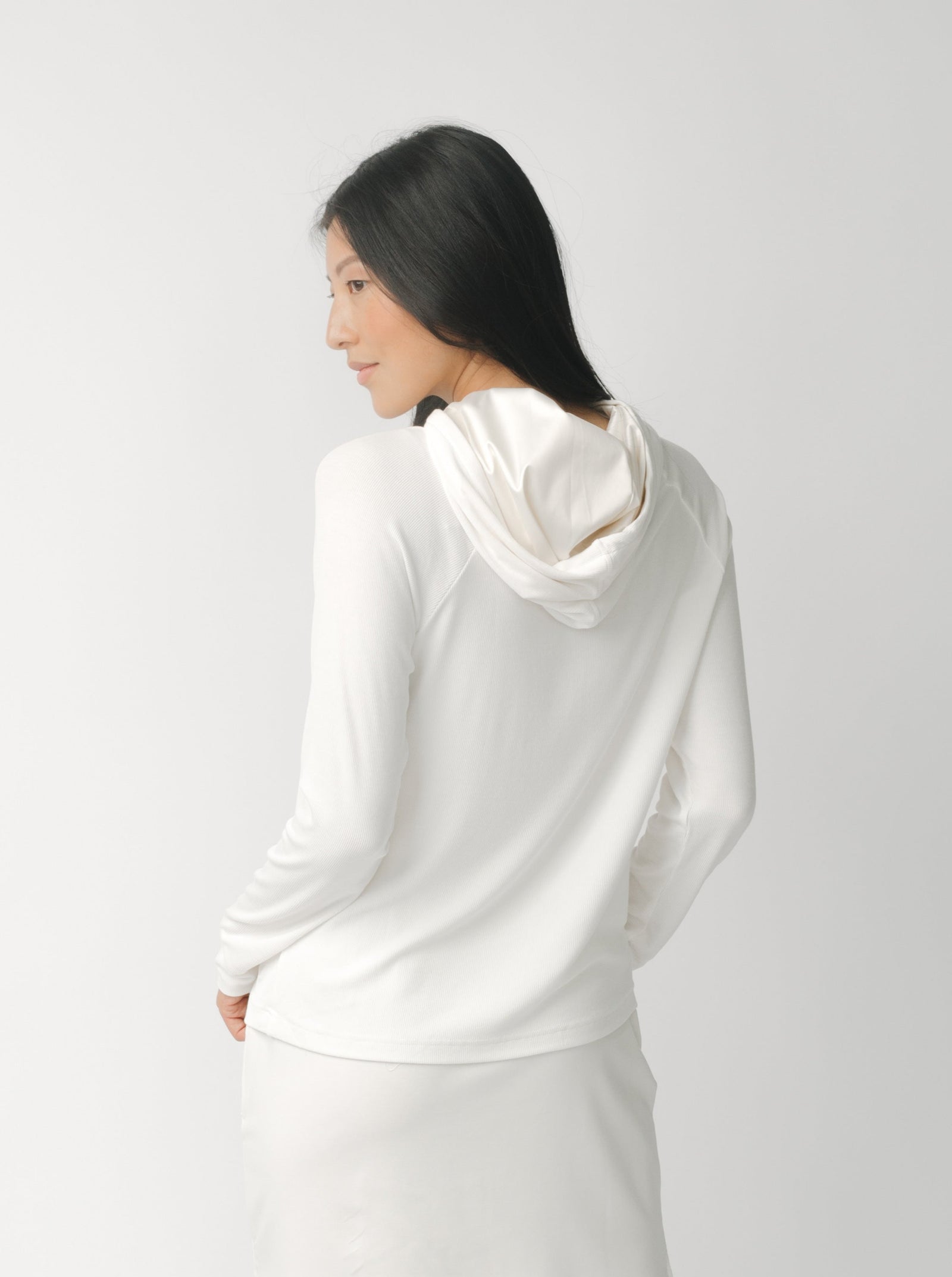 A woman wearing a white Cozy Earth Brushed Bamboo Hoodie against a plain background
