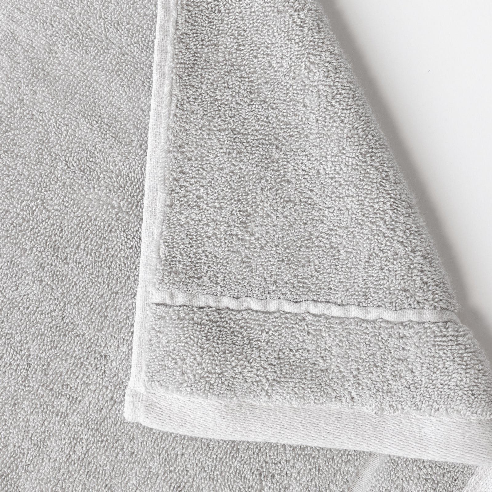Light Grey Premium Plush Bath Towel. Photo of Premium Plush Bath Towels taken on a white background showing only the corner of the towel. 