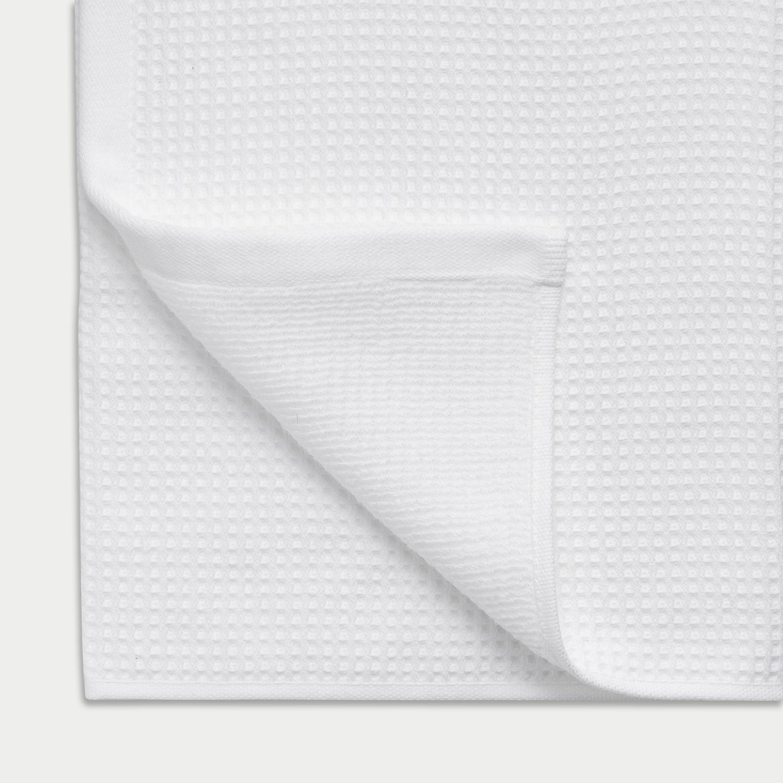 Waffle Bath Towel in the color White. Photo of Waffle Bath Towel taken close up showing the corner of the towel