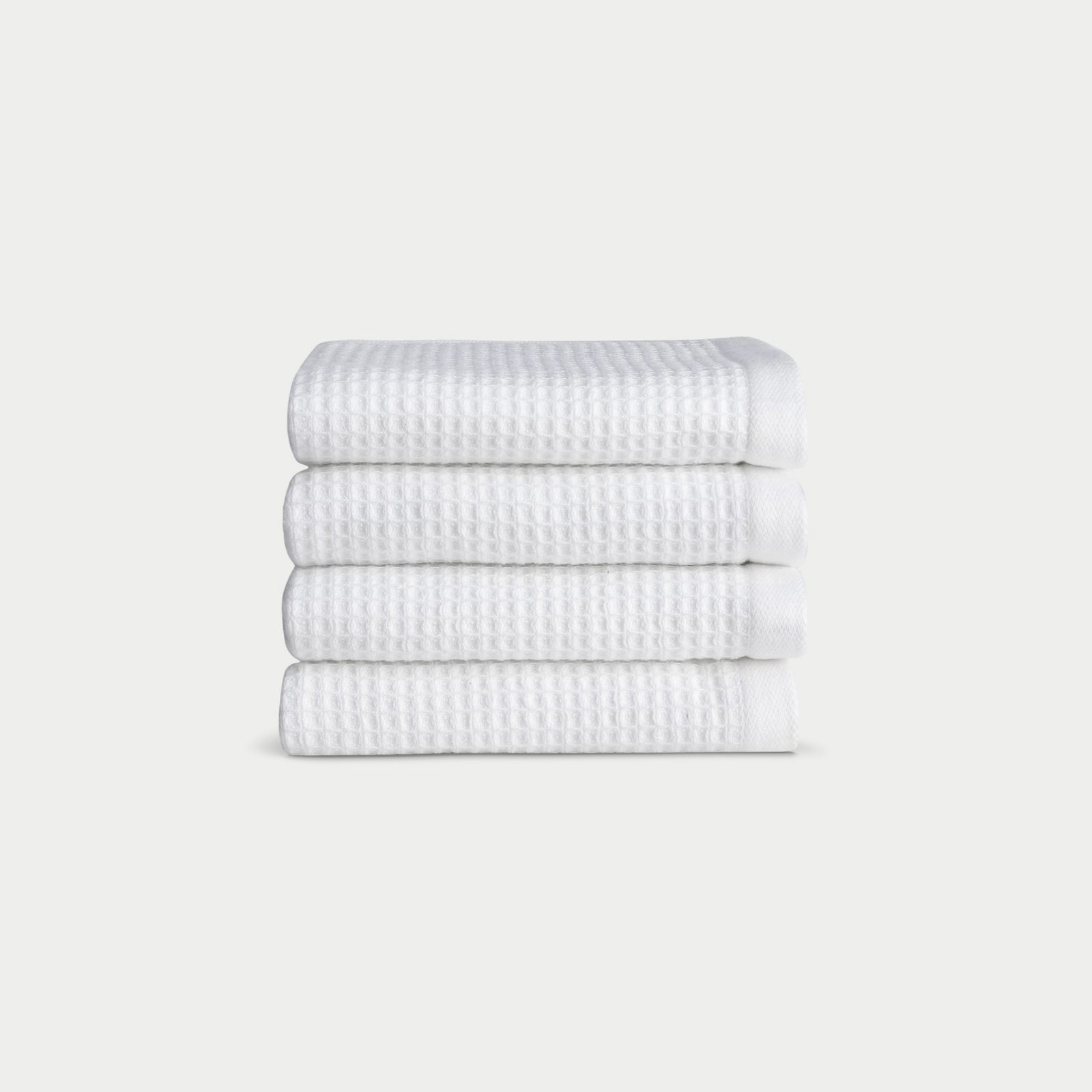 White Waffle Wash Cloths neatly folded. The photo was taken with a white background.
