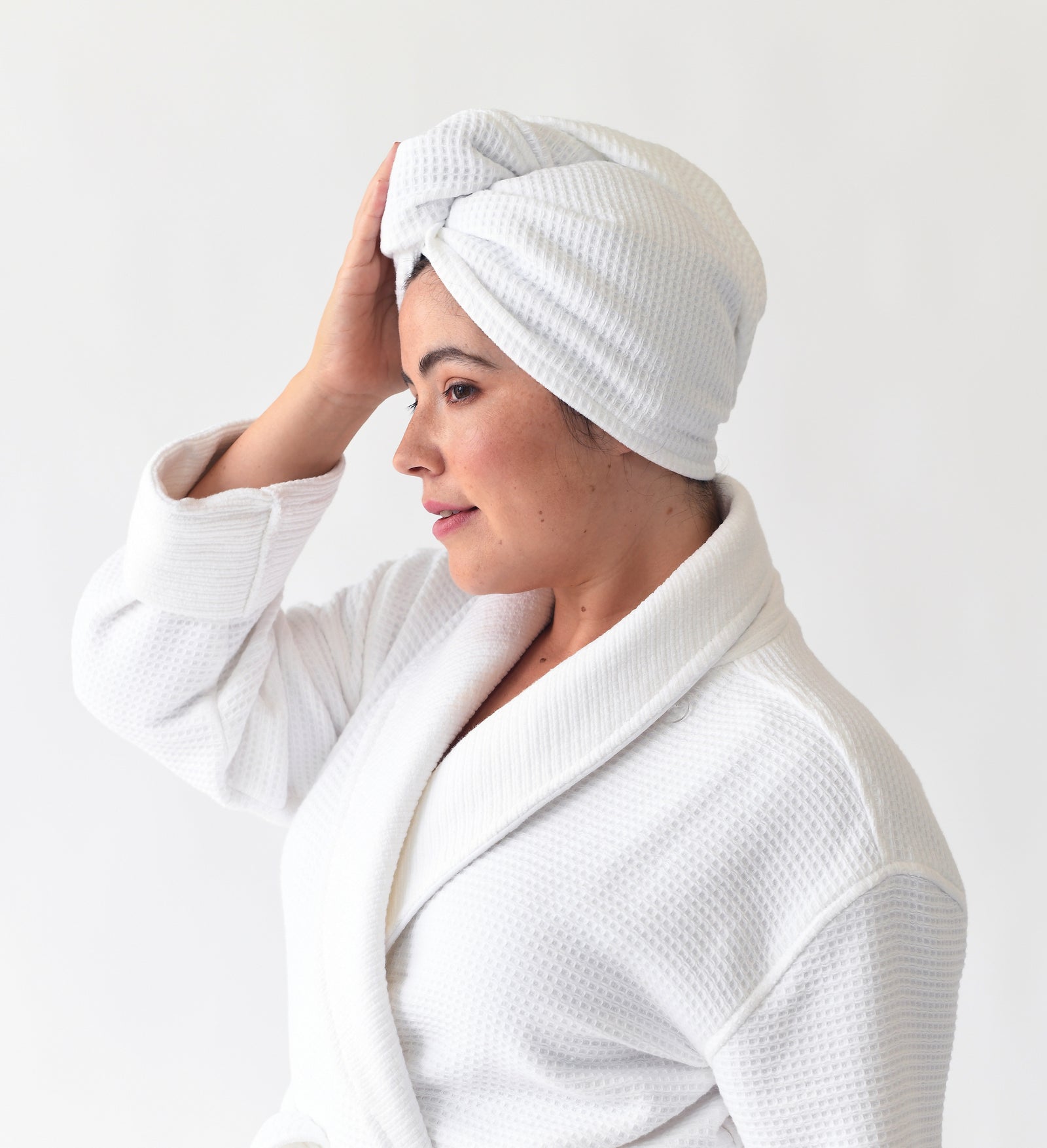 White Waffle Hair Towel. The hair towel is shown being worn by a woman. The photo was taken with a white background 