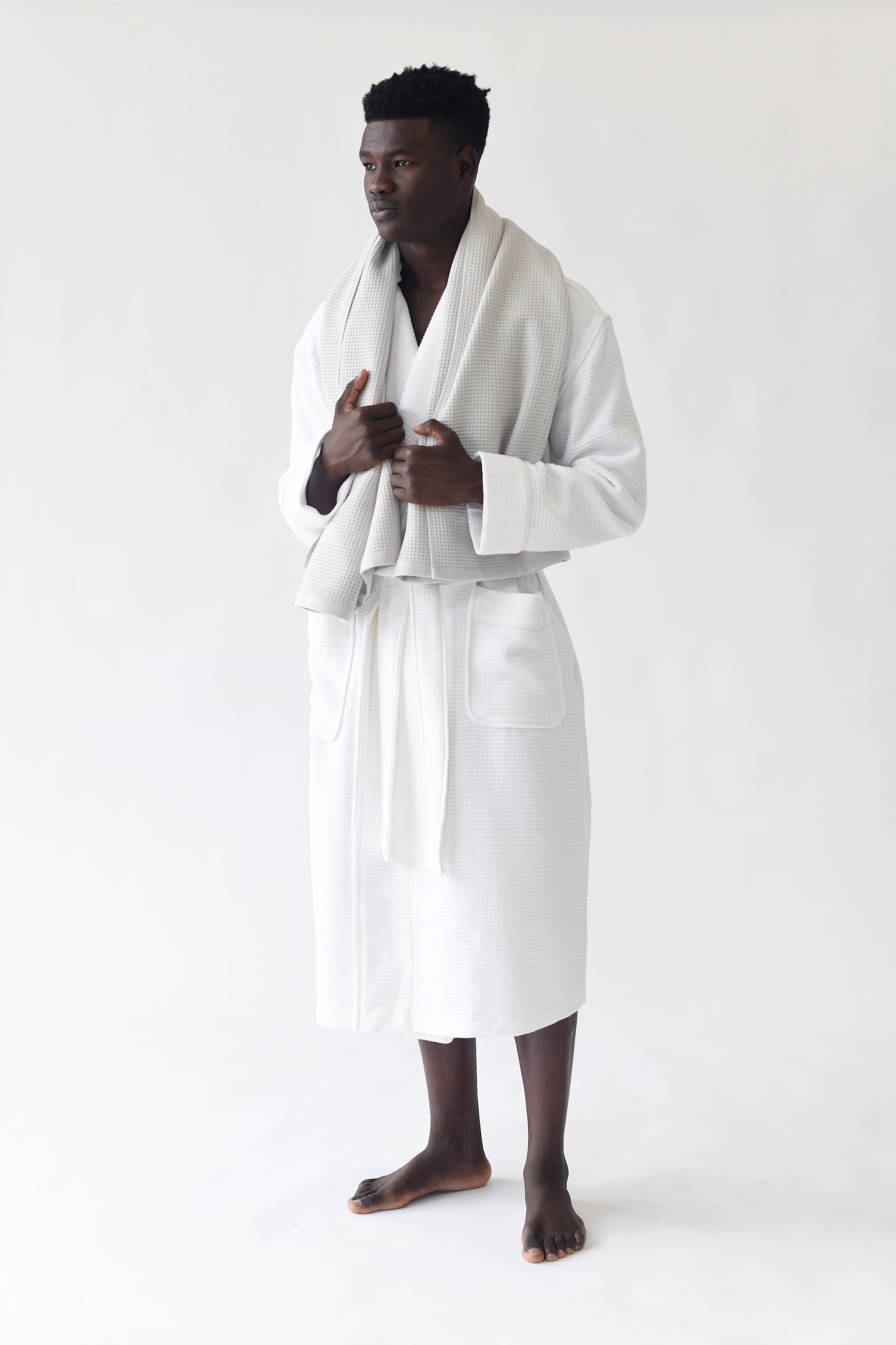 Man wearing Bamboo Waffle Bath robe standing in front of a with a white background. 
