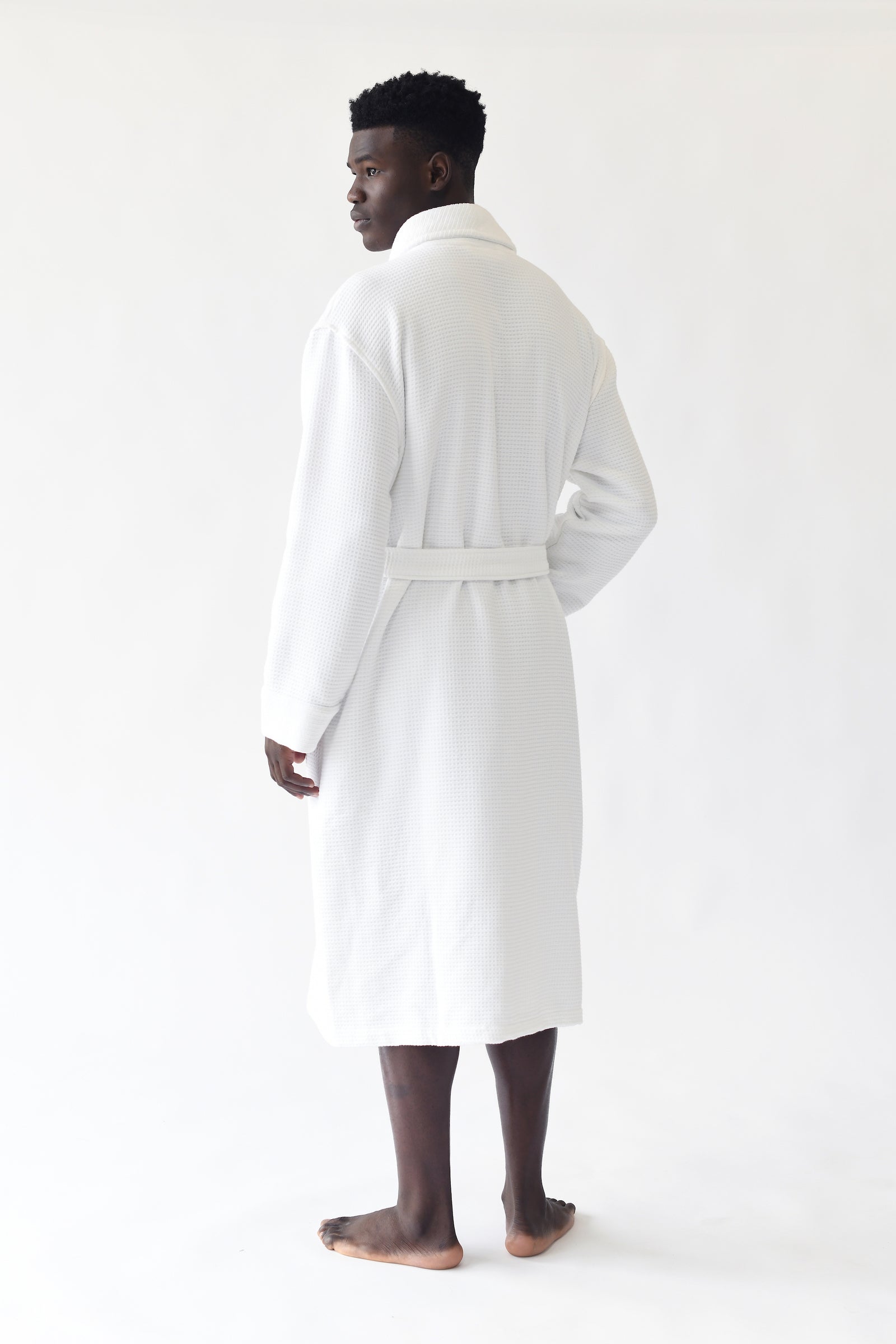 Man wearing Bamboo Waffle Bath robe standing in front of a with a white background. 