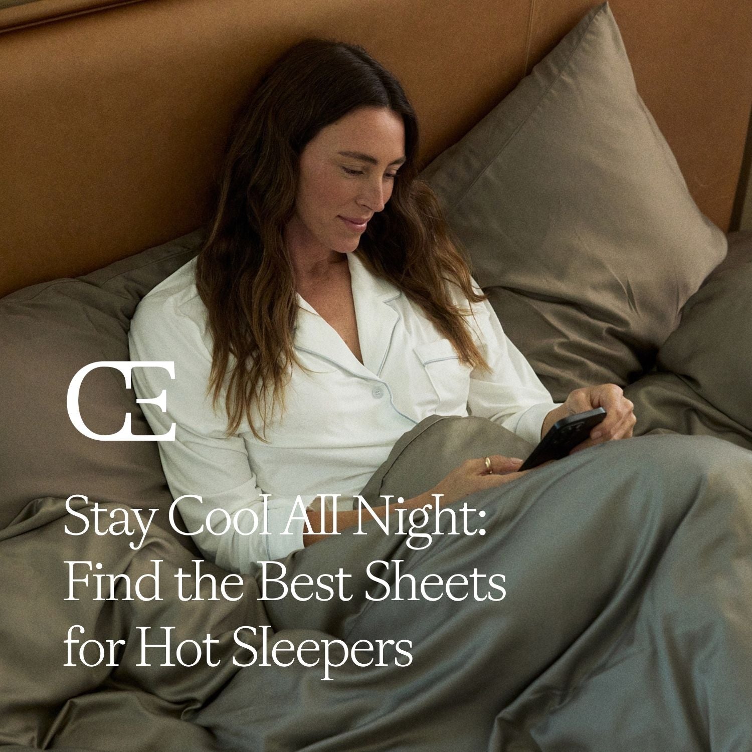 a woman lies in bed with grey sheets