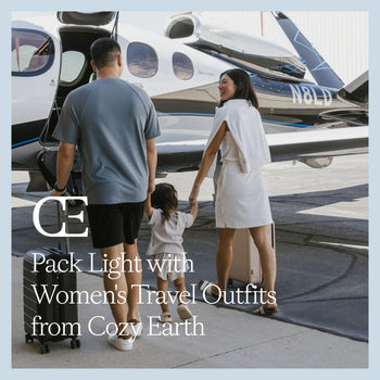 A man and woman hold the hand of a child and walk towards an airplane