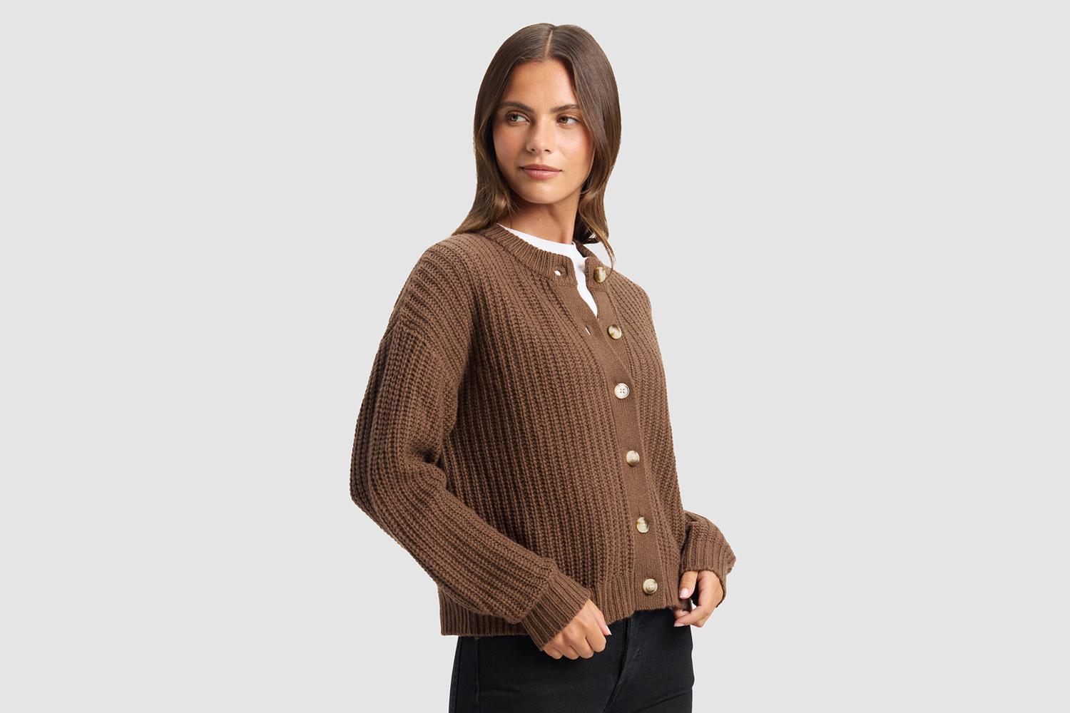 A person wearing a cozy, striped bathrobe with a belt tied at the waist, showing one hand adjusting the belt and two front pockets visible.