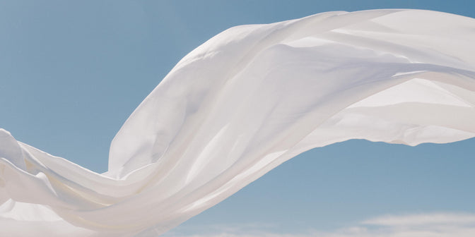 White sheet flowing in the air with blue sky background