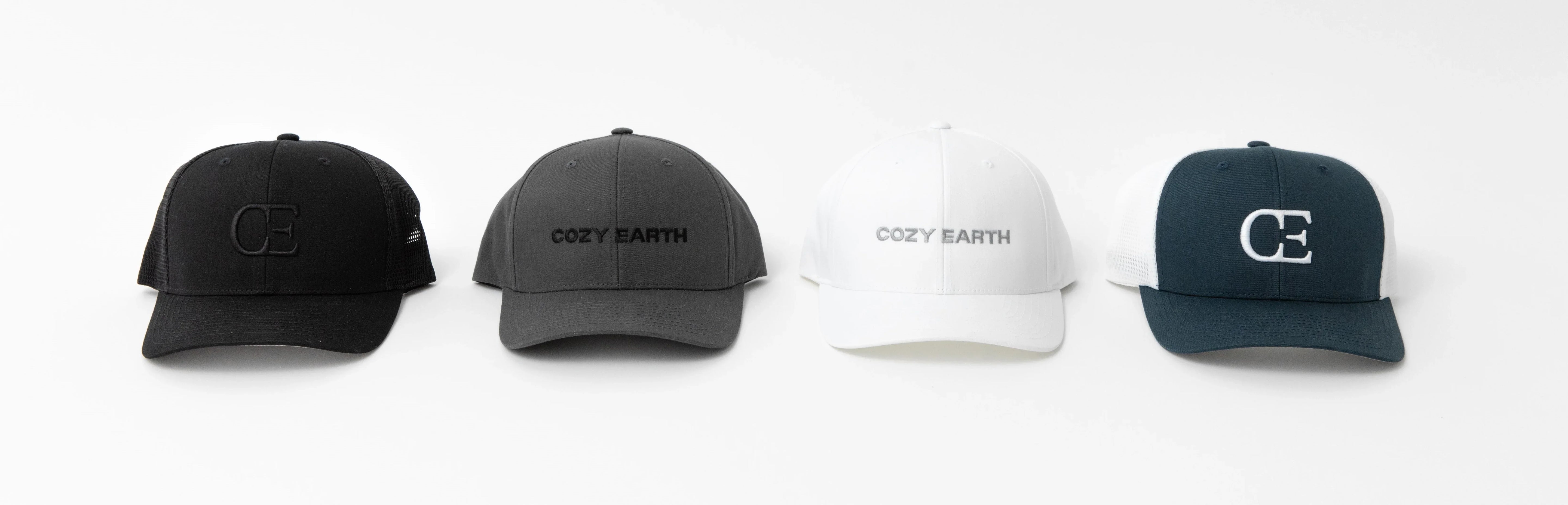 Four baseball caps are displayed in a row on a white background. The caps are in black, gray, white, and dark green colors, respectively. The first and last caps have the "CE" logo, while the middle two caps have the text "Cozy Earth.