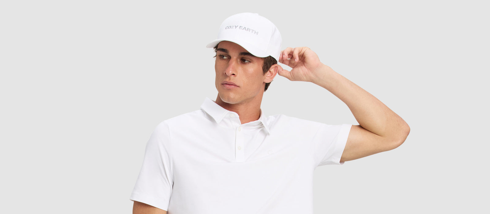 A man in a white shirt wears a white Cozy Earth cap