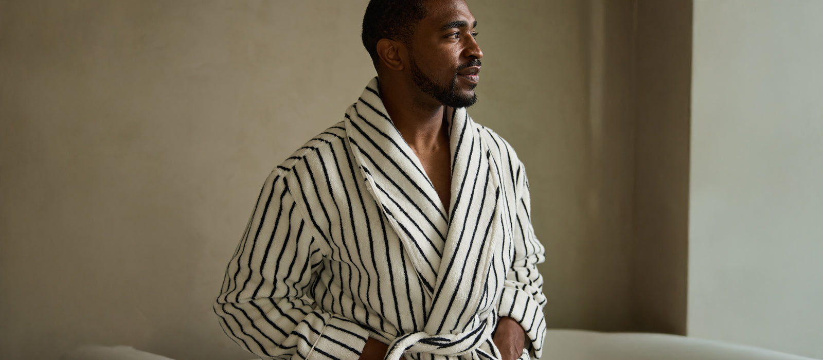 A man wears Cozy Earth Luxe Striped Bath Robe