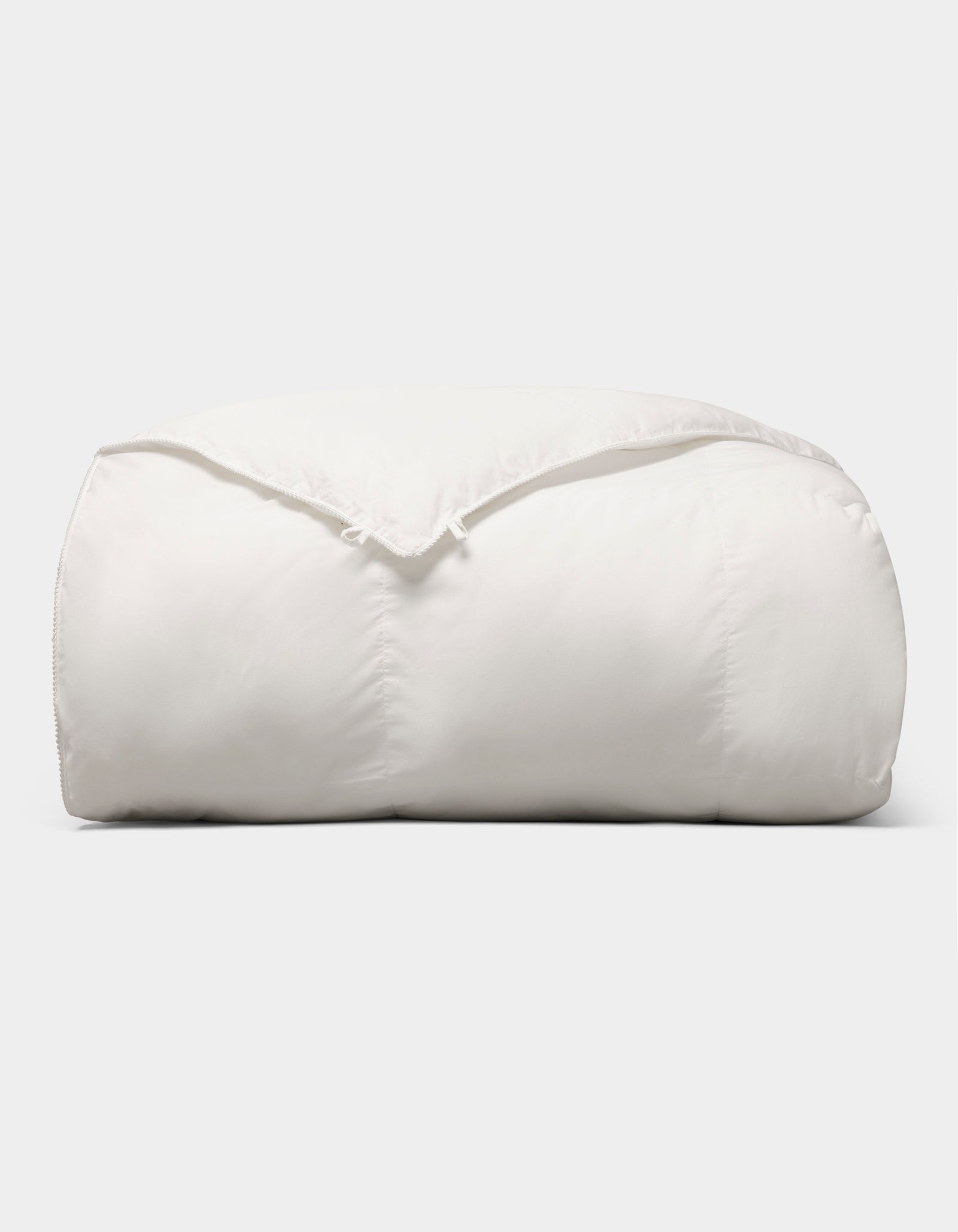 The Cozy Earth Down Alternative Comforter is neatly folded and fluffy, displayed against a plain light gray background. 