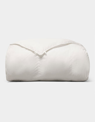 The Cozy Earth Down Alternative Comforter is neatly folded and fluffy, displayed against a plain light gray background. |Filling:Standard