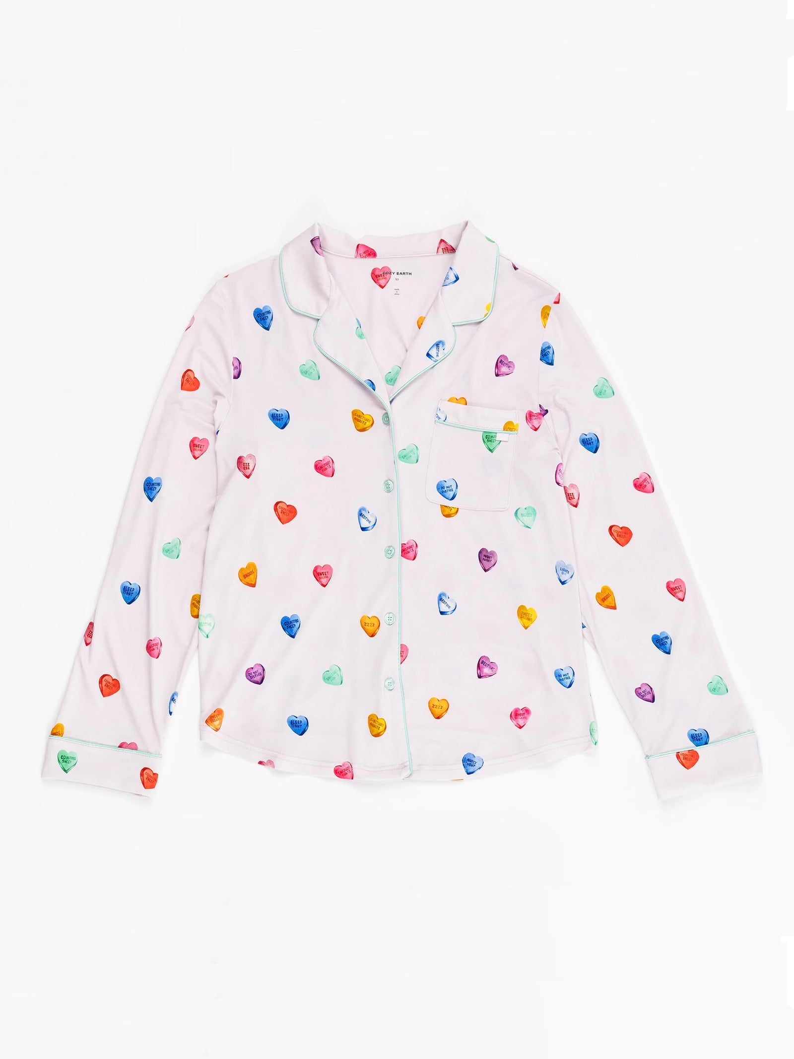 The Women's Long Sleeve Bamboo Pajama Top in Stretch-Knit by Cozy Earth features a lilac design with colorful heart patterns in blue, orange, red, and green. Light-colored buttons and piping add a playful and cozy look. 