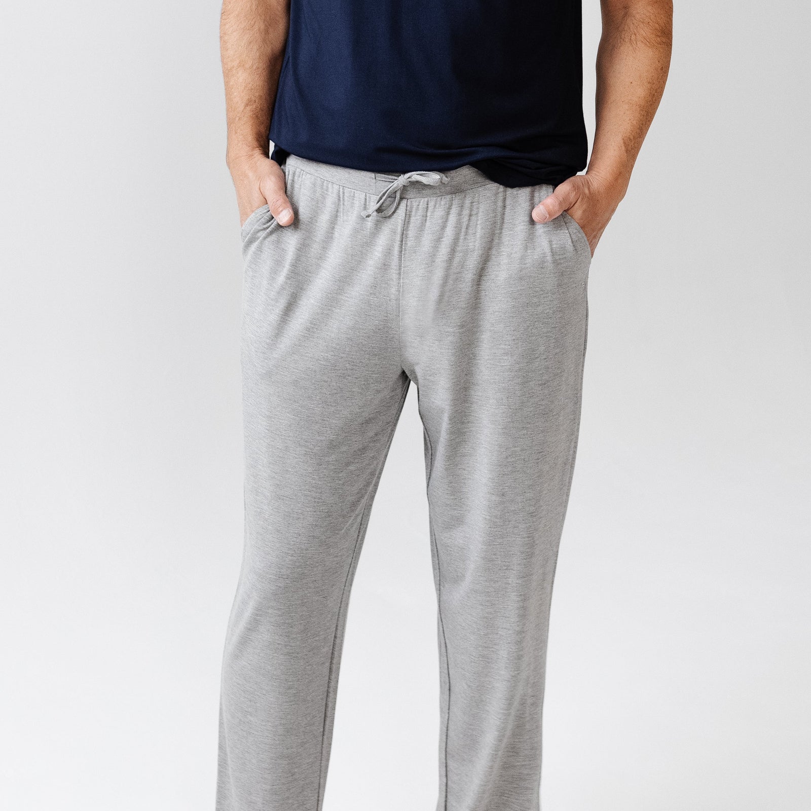 Man in heather grey pajama pants with white background 