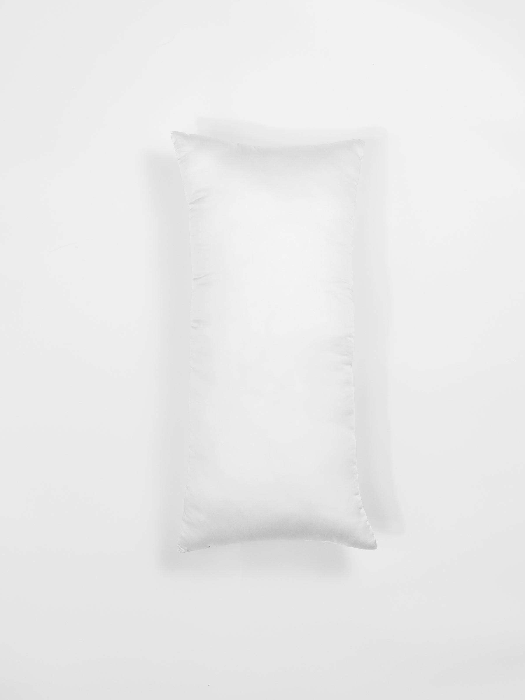 A white rectangular pillow from Cozy Earth's Premium Down Alternative Insert collection against a plain white background. The pillow sports a clean and simple design, featuring a smooth surface with faint seams visible along the edges. |Size:14"x30"