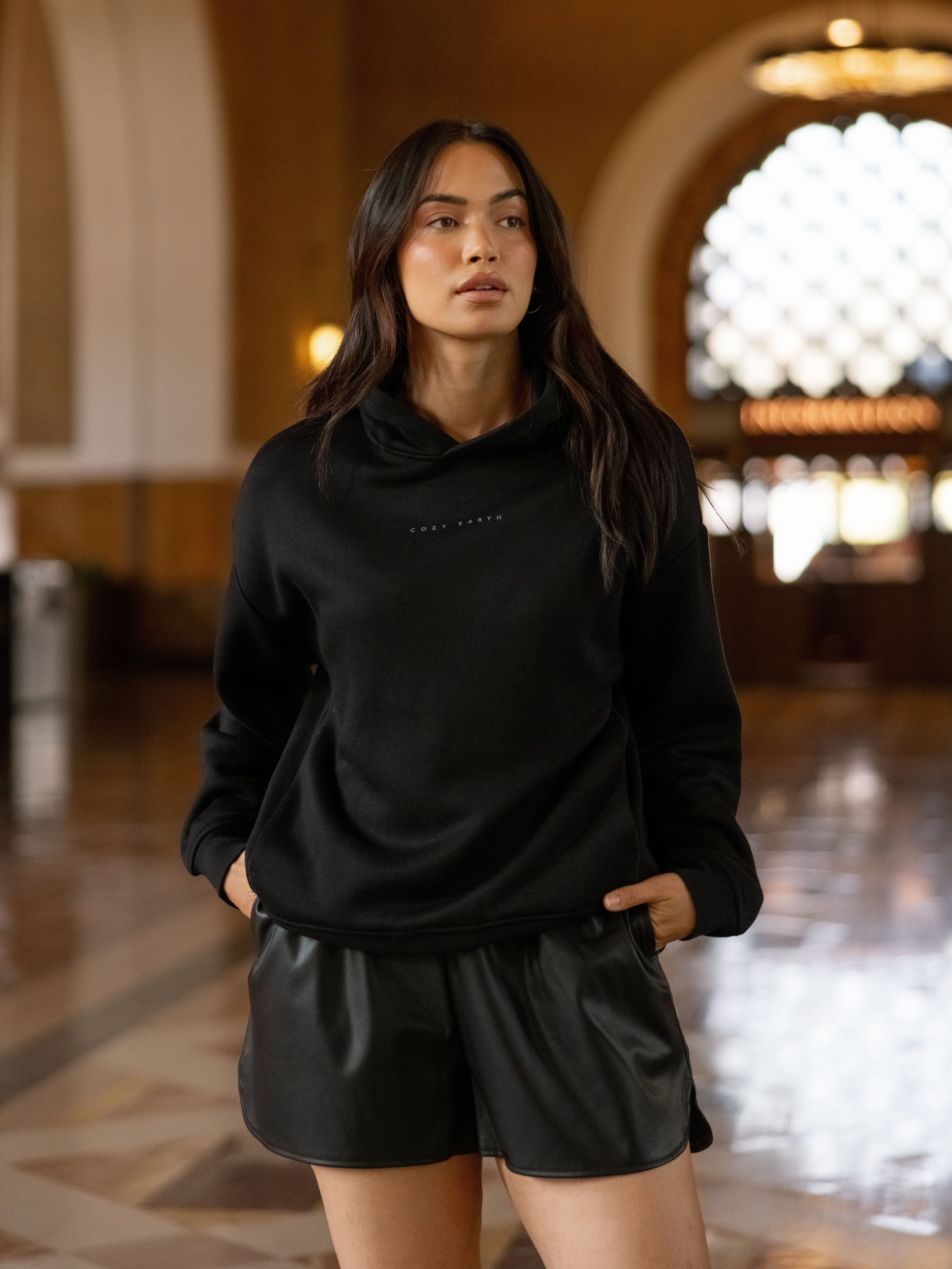Woman in building wearing black cityscape hoodie 