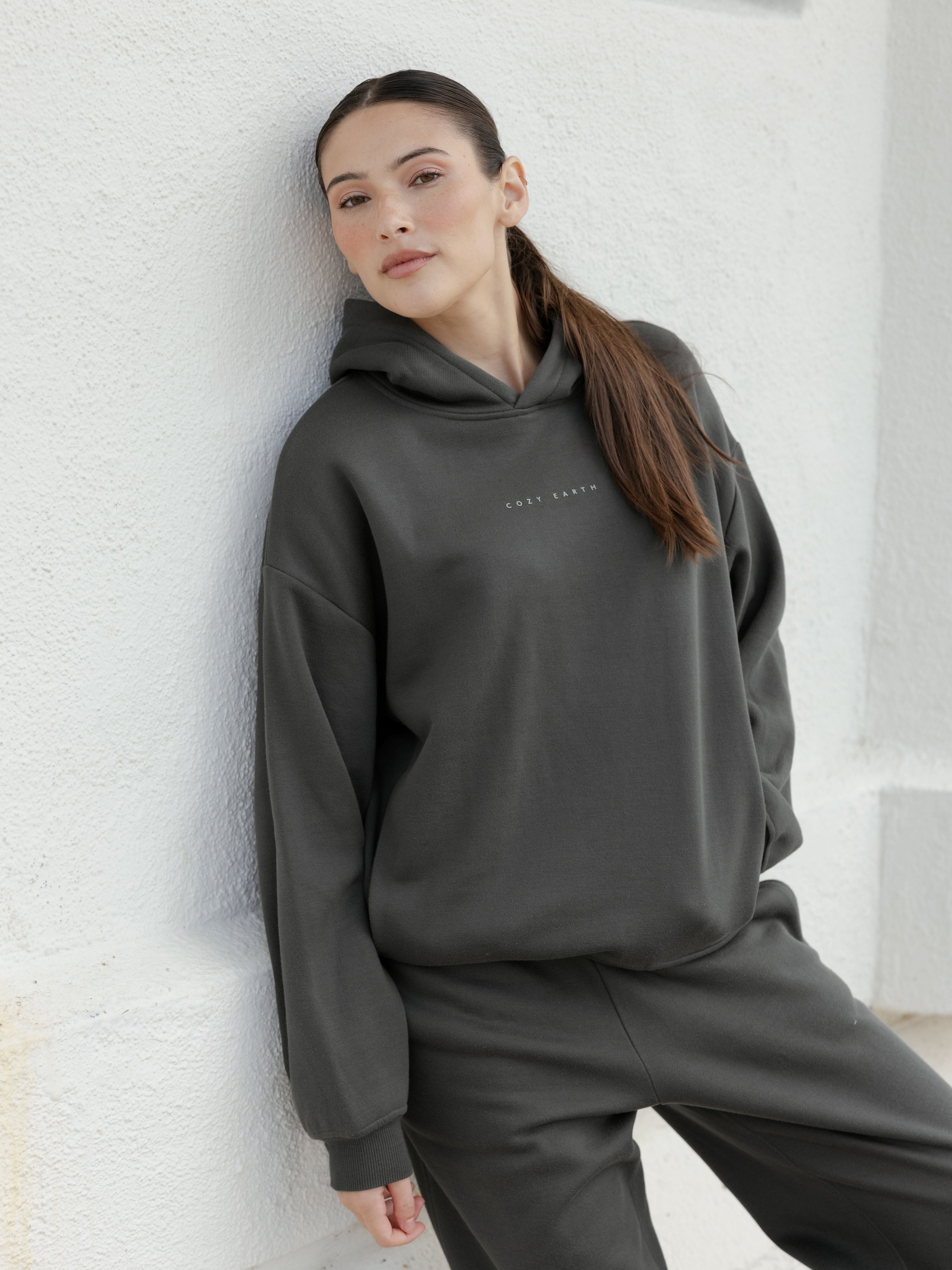 Woman in storm cityscape hoodie leaning against wall |Color:Storm