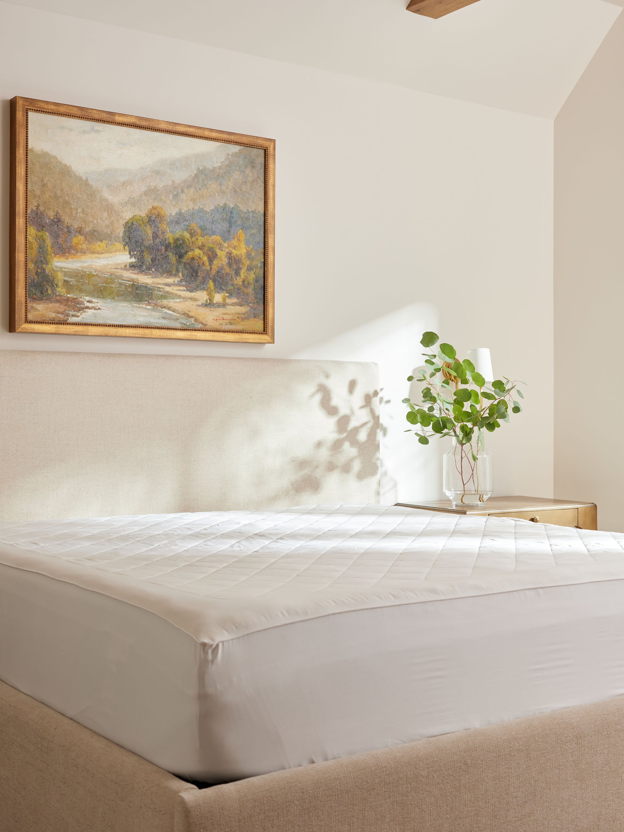 Bamboo Mattress Pad on bed with nightstand and painting in the room