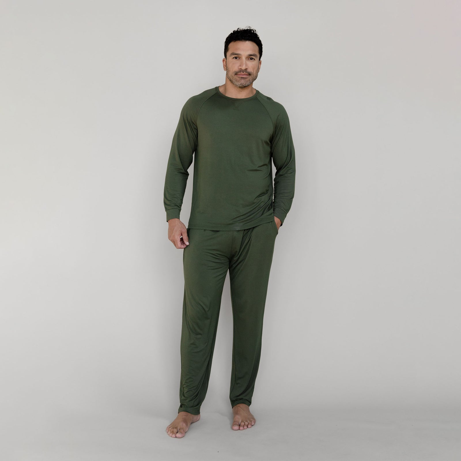 Man in olive long sleeve pajama set with white background 