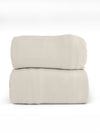 A neatly folded, light beige Bamboo Jersey Sheet Set from Cozy Earth is placed against a plain white background. The fabric appears smooth and soft, creating a simple and minimalist composition. |Color:Birch