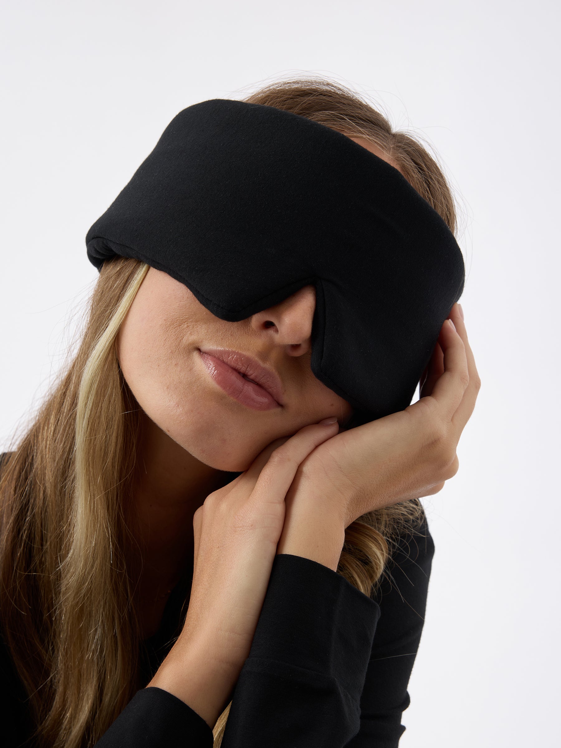 A woman wears the Cozy Earth Adjustable Bamboo Sleep Mask in Black. |Color:Black