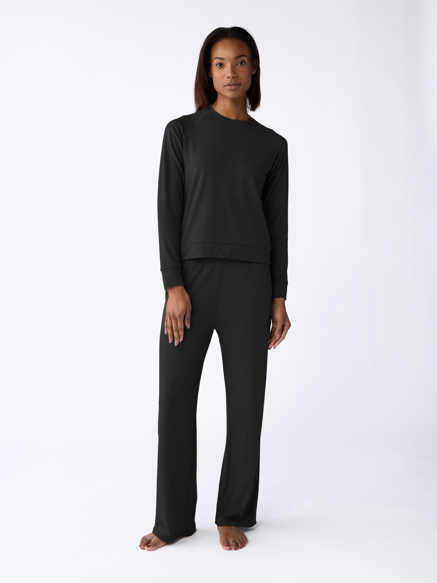 A person is barefoot, wearing the Cozy Earth Women's Ultra-Soft Bamboo Wide Leg Pull On Pant & Pullover Crew Set against a light background. |Color:Black