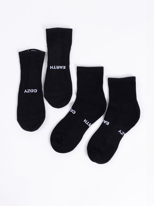 Four black socks from the Cozy Earth Essential Quarter Sock 2-Pack are displayed on a white background. Two of the socks feature the word 